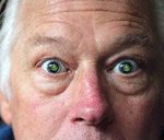 Senior man high on marijuana with marijuana leafs in his eyes.
