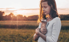 Christian teenage girl holds a Bible in her hands.