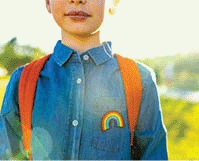 Girl in denim t-shirt with rainbow symbol.