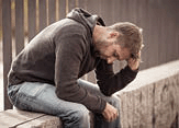 A young man suffering from depression stress sitting alone.