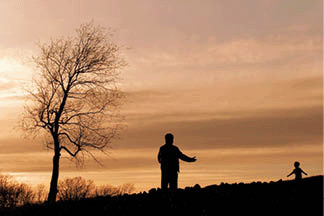 A silhouette of a parent opening his arms to a child running toward him.