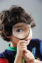 Boy looking through a magnifying glass.