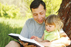 Young father with his little daughter reading from the Bible.