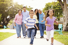 A multi-generational family is walking in a park together.