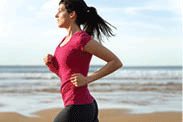 Woman jogging along the ocean.