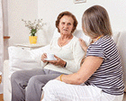 Caregiver having tea with an elderly woman.